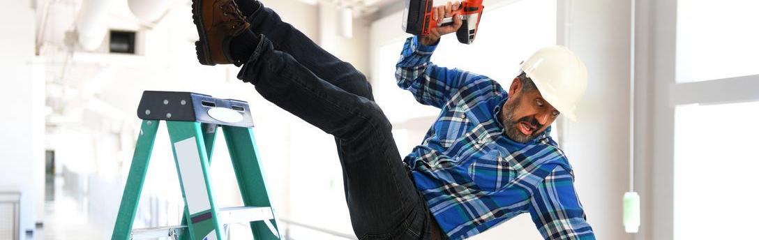 Man falling off ladder while holding a drill